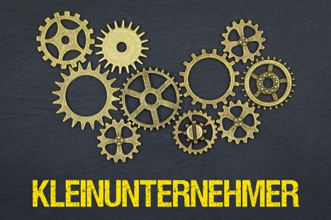 Foto: Zahnräder und Schriftzug Kleinunternehmer